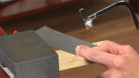 Metal sheet being cut with a jewelry saw