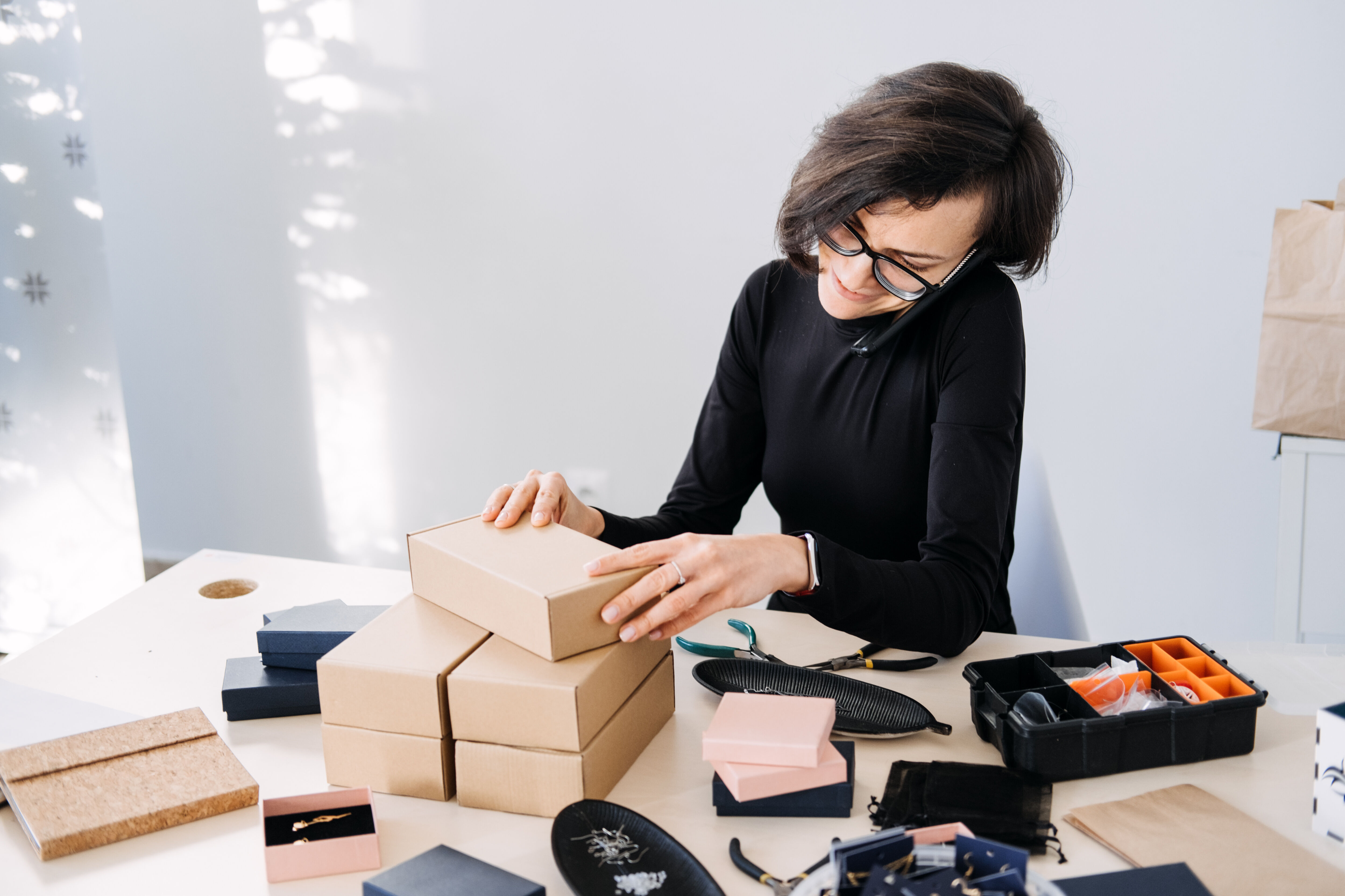 Woman on the phone closing a box