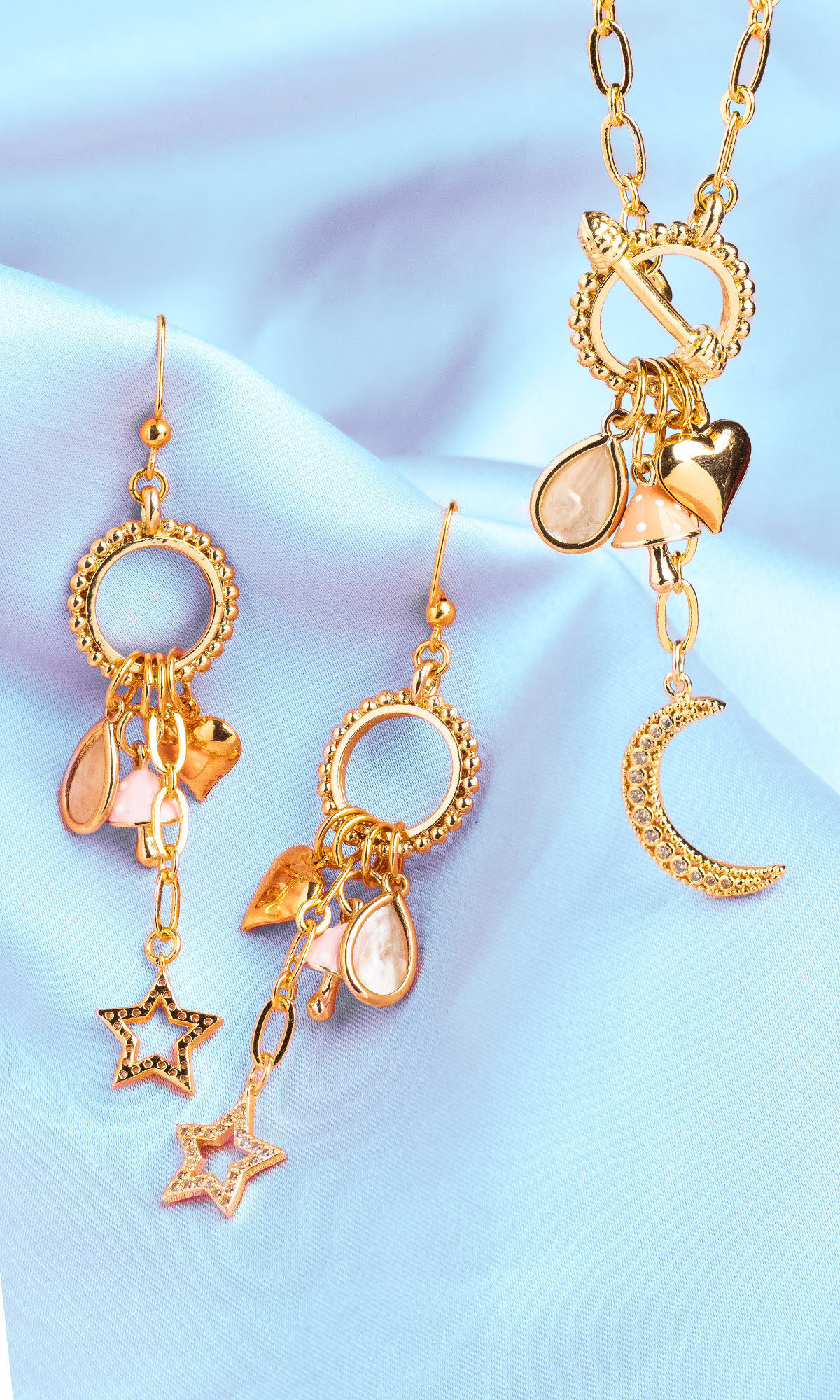 Earrings an Necklace displayed on light blue fabric