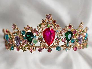 Sparkling golden tiara with pink, green and blue gemstones.
