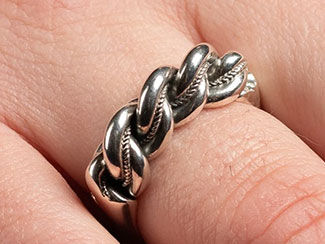 Silver ring with three twisted bands being worn.