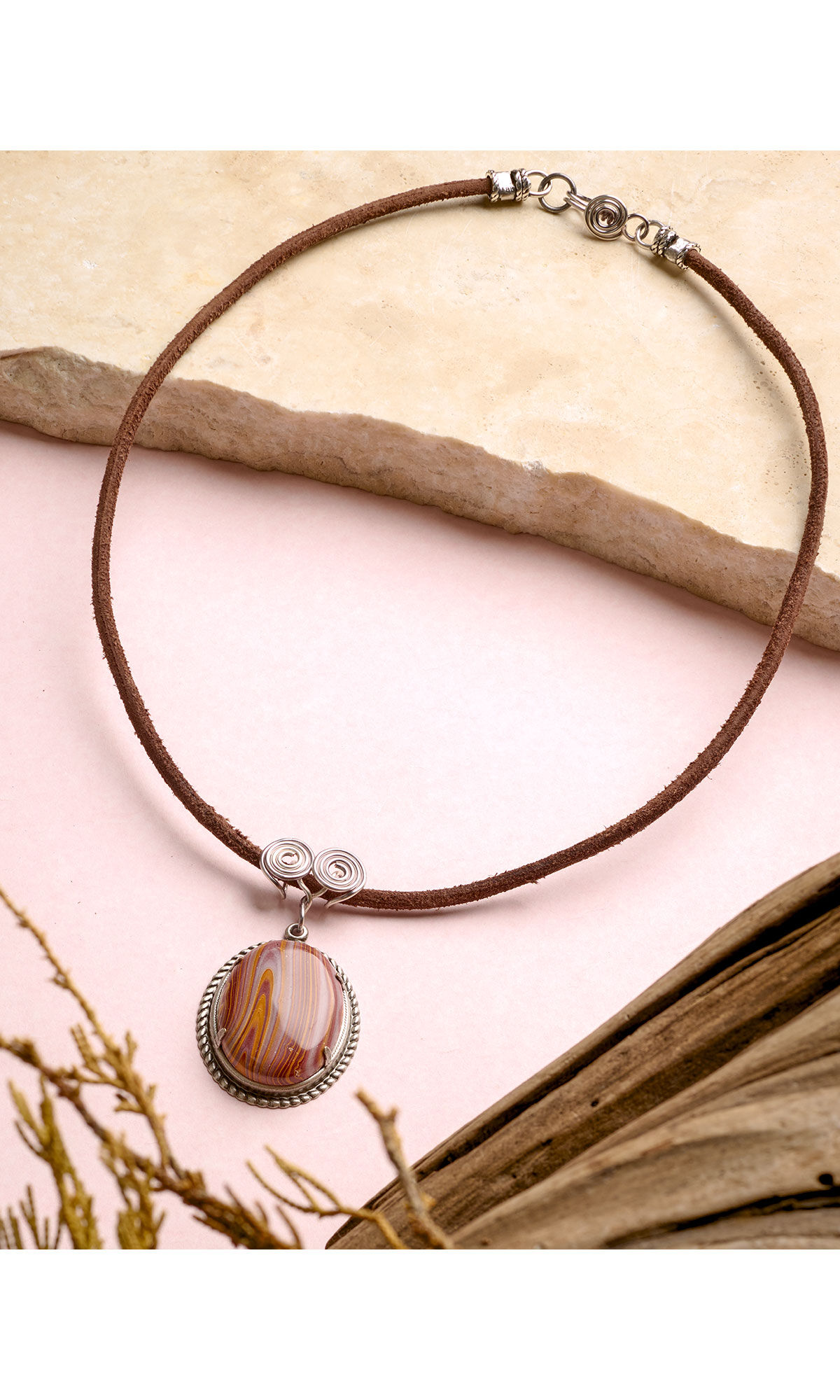 Design Idea R F 4 D with Leather Cord and Natural Autumn Hickoryite Oval Cabochon laying on a piece of beige marble 