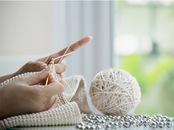 A person crocheting with white yarn
