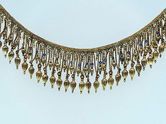 Necklace has fringe of beaded drops, each ending in a pear-shaped metal drop.
