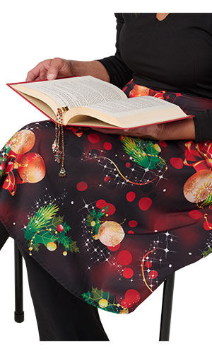 An open-book rests on a lap, featuring a dangling bookmark with delicate, shimmering beads and charms cascading down the fabric.
