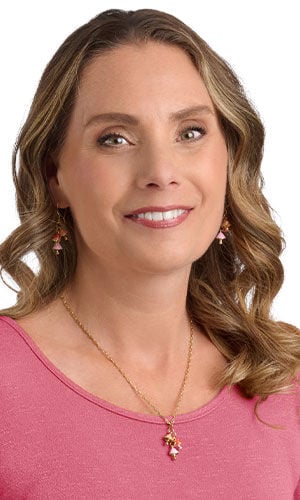 a smiling woman in pink wearing Design Idea R J 2 2
