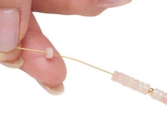 Step 5 showing pink heishi beads being strung onto beading wire