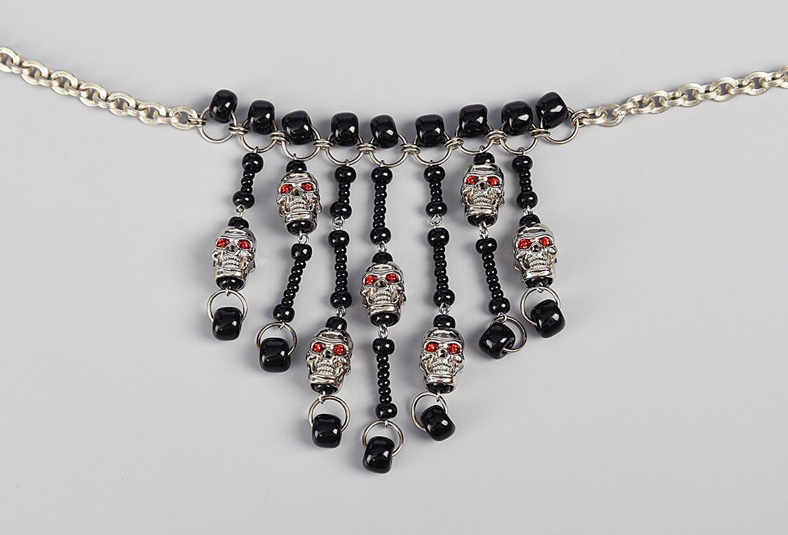 Necklace with seven dangles featuring black seed beads and skulls
