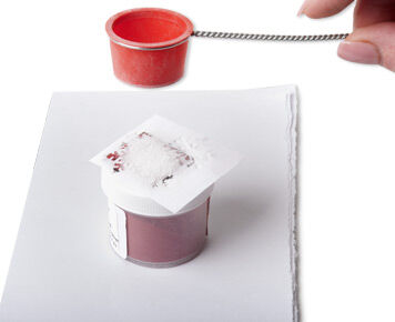 Enamel being sifted over metal