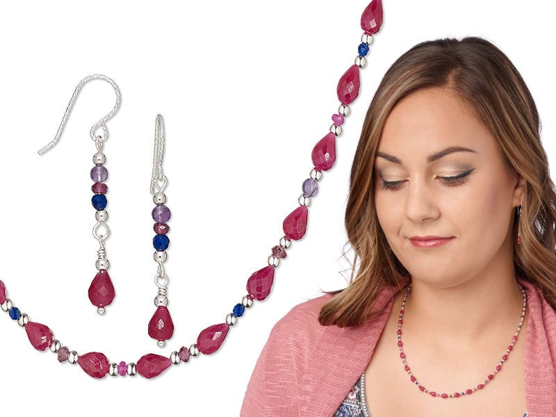 Model wearing a necklace and earrings with some garnet gemstones