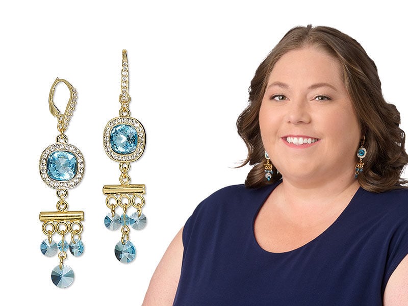 Model wearing a necklace and earrings with aquamarine colored crystal 