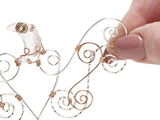 Step 8: Spirals of wire and crescent moon component are attached to each other with copper wire