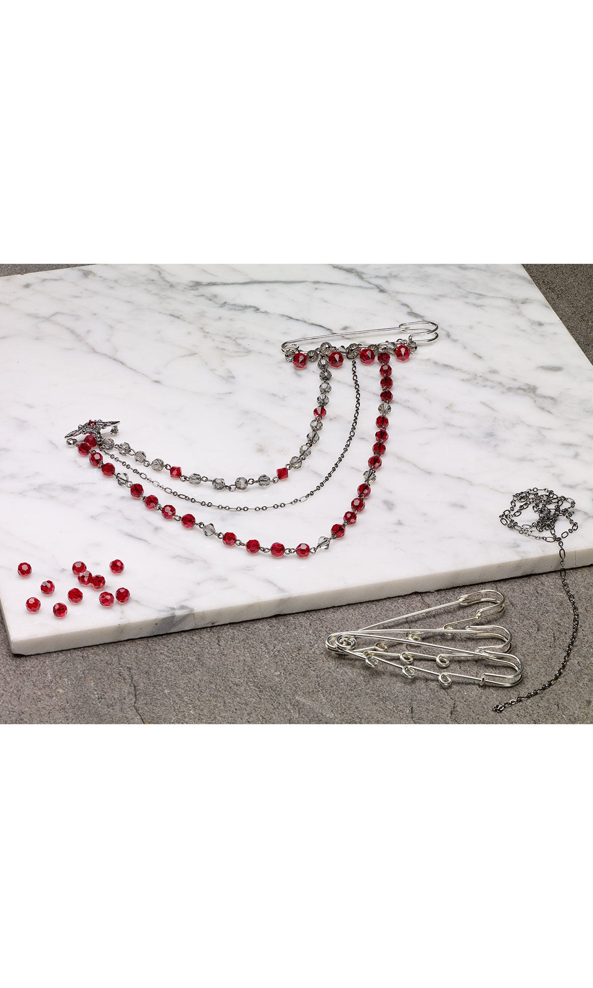 Design Idea R M 2 B on a white surface next to beads and findings