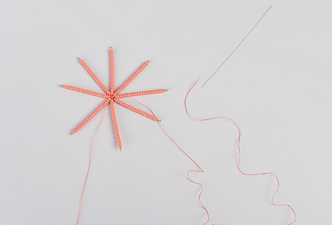 Ornament frame with orange seed beads on all eight prongs