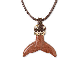 An image of a necklace with a goldstone whale tail component 