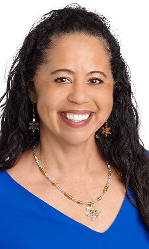 Woman wears a beaded necklace with a snowflake pendant and matching snowflake earrings.