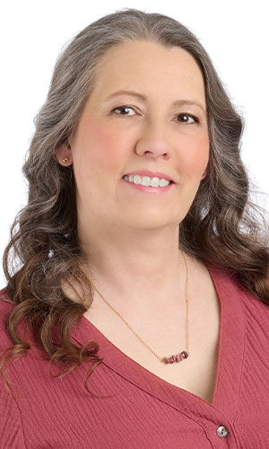 A smiling woman in pink wearing design Idea Q B 2 C
