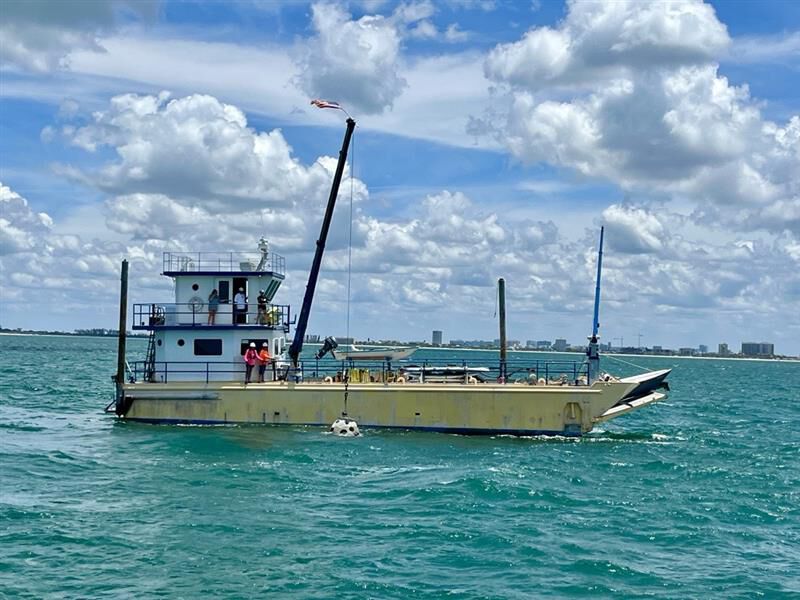 Boat lowering a reef into the ocean