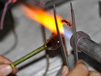 Shaping glass with tongs and a torch