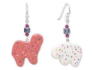 Design Idea S B 2 U - Each earring has a silvery fishhook component from which hangs a drop with a purple crystal cube bead surrounded by small fuchsia bicones. The pendant on each earring is a polymer clay frosted animal cracker with tiny beads to represent the sprinkles on the cookie. One cookie is pink and the other is white.