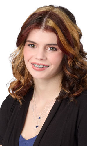 Model wearing black blazer modeling layered necklace set