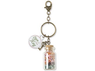 Design Idea N A 2 Y - Antiqued gold-color split ring hangs from links of similarly color chain with a lobster claw clasp with a heart design at the top. Hanging from the split ring are three charms: A key, a flat circular component that says, &ldquo;Love is the Key&rdquo; and a clear bottle with a cork filled with chip beads.
