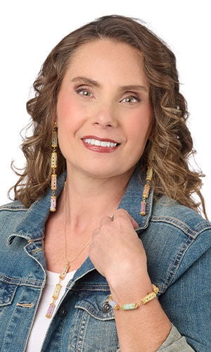 woman in a denim blue jacket wearing Design Idea S D 3 S &ndash; Jewelry set includes necklace, bracelet and earrings and features segments of stacked pastel half tila rectangle seed beads with gold chain and findings.