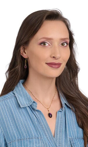 Model wearing blue blouse modeling necklace and earrings