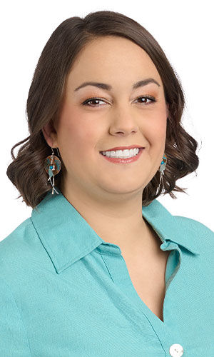 model in a turquoise top wearing Design Idea S A 2 A - Each earring has a disk of patinaed copper with silver hammered wire and blue gemstones suspended in front of it.