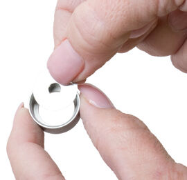 Extruder die being placed into cap