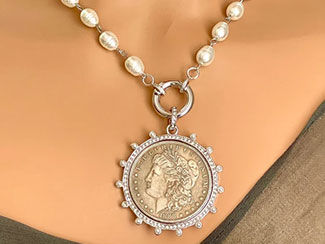 Necklace of pearl and chain has a pendant with a coin in a silver setting