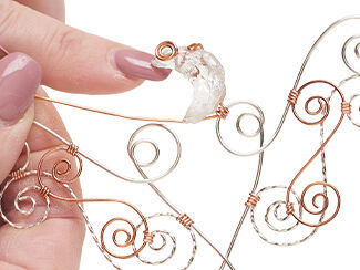 Step 7: Quartz crescent moon being attached to spiraling wire with copper wire
