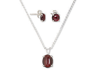 An image of a garnet cabochon focal and earrings in settings on necklace chain and ear wire