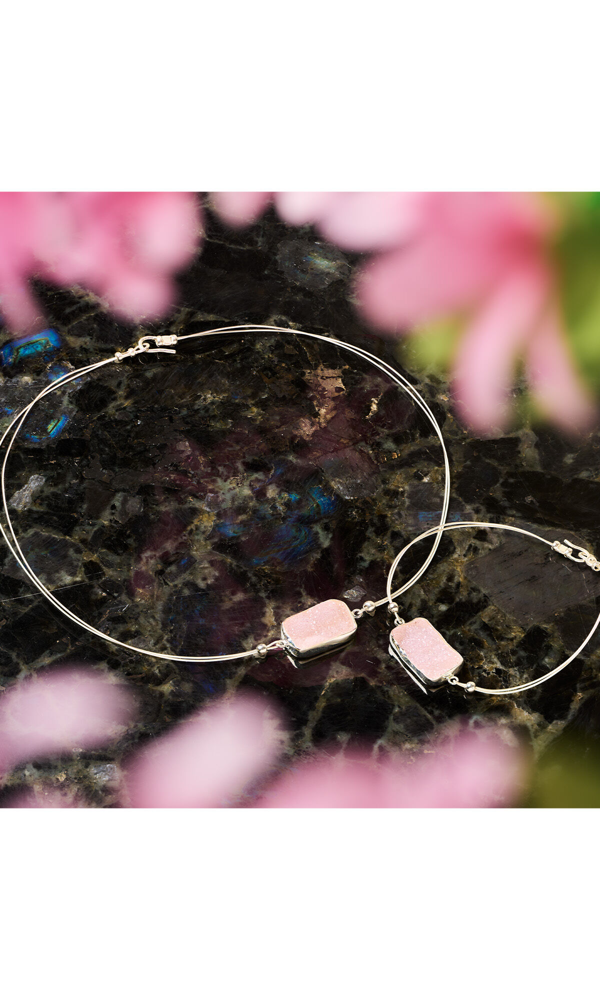 wire necklace and bracelet with rectangular pink druzy agate focals on a dark background with pink flowers around
