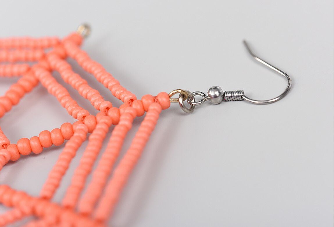 Ear wire attaches to one prong of the ornament frame.