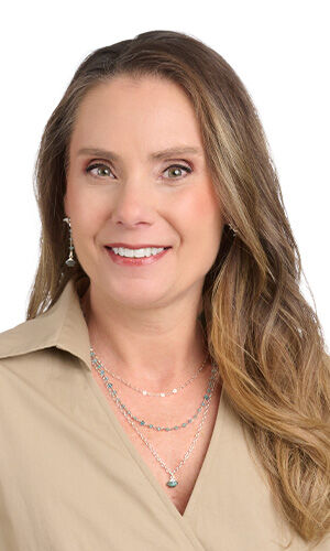 Model wearing tan blouse modeling necklace and earrings