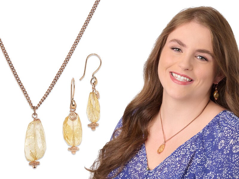Model wearing a necklace and earrings with citrine gemstones
