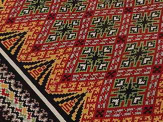 Carpet with red, green, white, gold and black geometric designs
