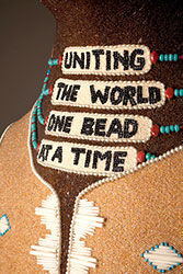Neck of beaded bear "Uniting the world one bead at a time"