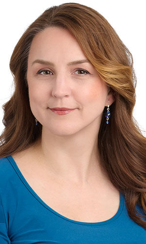 model in a blue top wearing design idea R J 2 V Lightly wire-wrapped blue crystals dangle from silver ear wires.