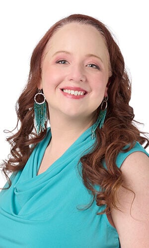 Model wearing Design Idea R K 2 P silver hammered earrings with long turquoise beaded fringe, a portrait view.