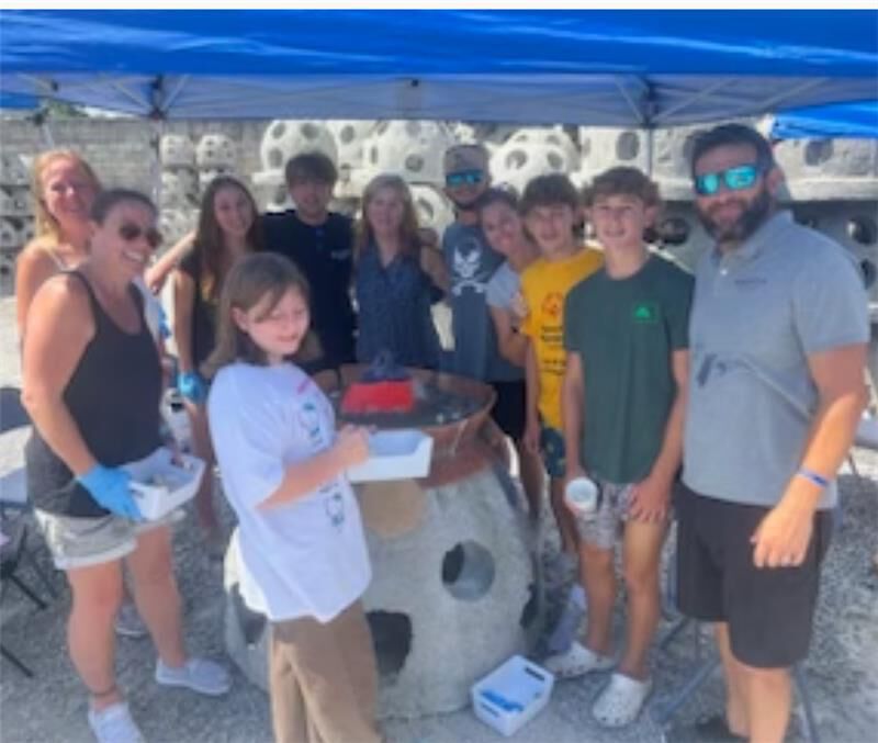 A group of people around a coral cast