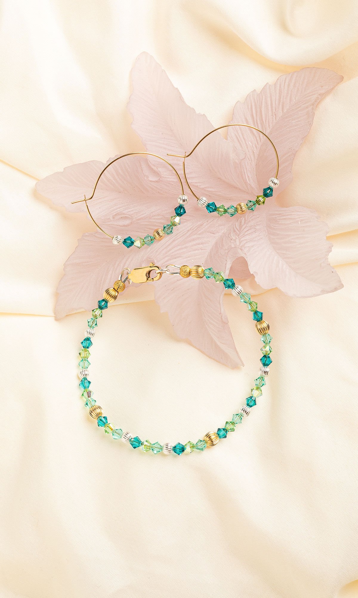 bracelet and earrings on ivory cloth with flower