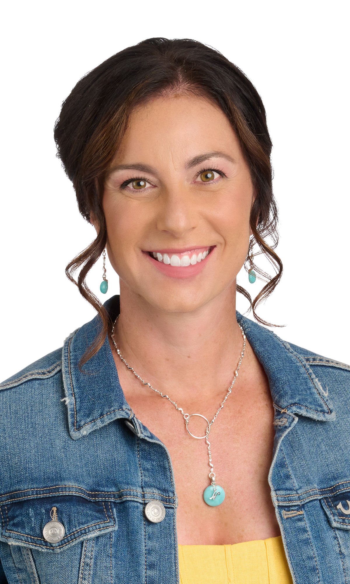 Woman wearing jean jacket, yellow shirt and light blue gem necklace