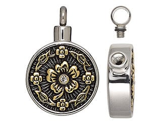 Silvery round container pendant with a loop on the top and black and golden flower and leaf designs on the front.