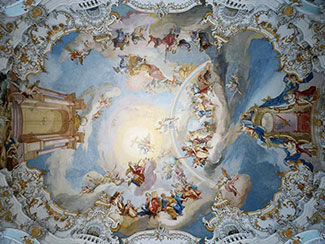 Ceiling with a painting of multiple heavenly figures with prominent colors of blue, white, fuchsia and gold