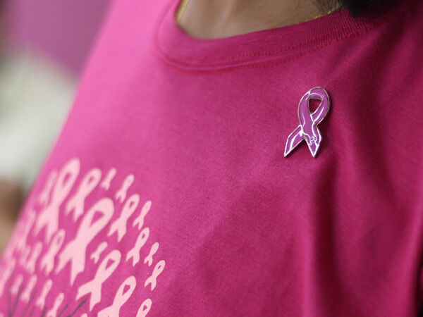 Pink shirt with a breast cancer awareness ribbon pin