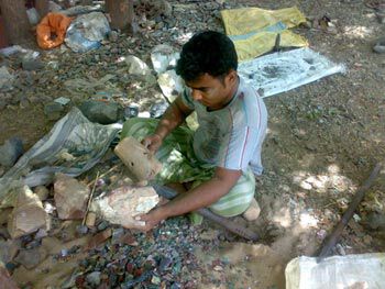 Man with a wooden mallet and a stone