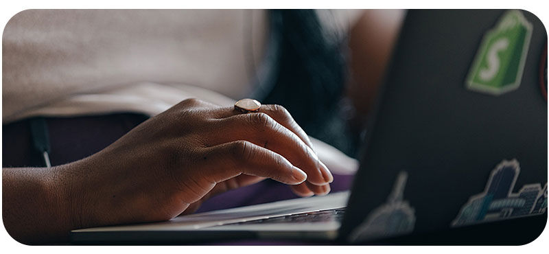 Hands typing on a laptop