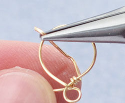 Wire being wrapped around loop by pliers